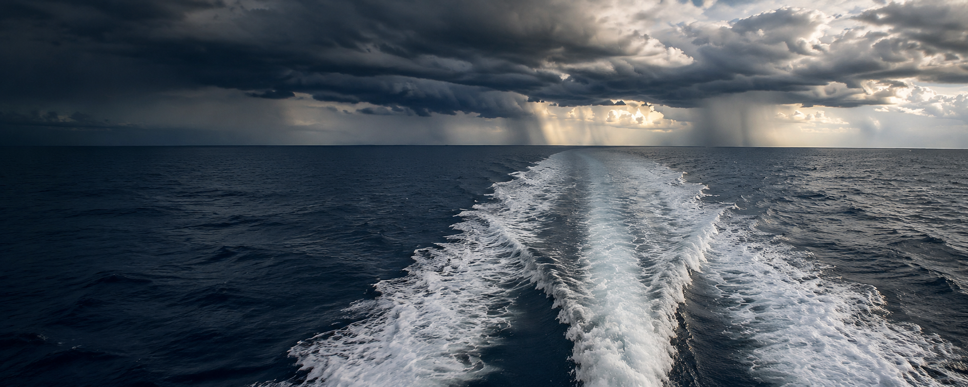 Boat wake under dramatic clouds on open water